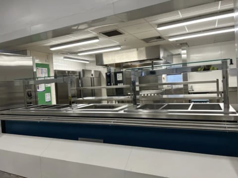 Commercial kitchen servery with stainless steel counters