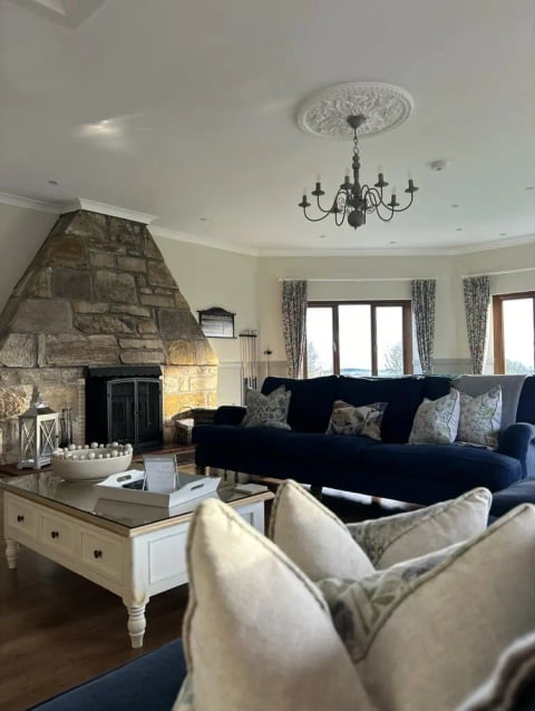 Hawkswood living room with a blue sofa and stone fireplace