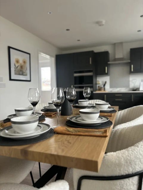 Dining table laid with glasses and candles after a sparkle clean